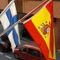 Kuvassa on Suomen ja Espanjan liput kaupungin kadulla.